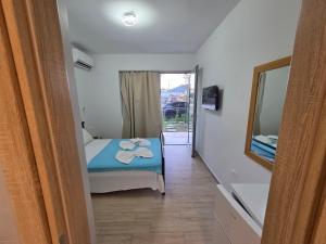 a bedroom with a bed and a mirror and a bathroom at VasilikiApartments in Vasiliki
