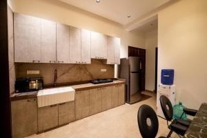 a kitchen with white cabinets and a refrigerator at Woods Luxury Villas in Lonavala