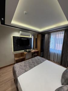 a hotel room with a bed and a flat screen tv at Nil Hotel in Gaziantep +14 photos