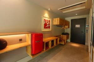 a kitchen with a red refrigerator and wooden cabinets at Warehouse By The Stay in Alaçatı