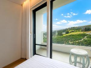 a bedroom with a bed and a large glass window at Jeju BunkerHotel&Resort in Seogwipo