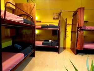 a room with three bunk beds in a room at Home Sol Guesthouse in Pantai Cenang