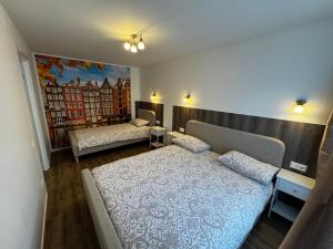 a bedroom with two beds and a painting on the wall at Amstel LUX in Narva