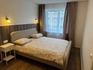 a small bedroom with a bed with a window at Amstel LUX in Narva