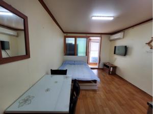 a room with two beds and a table in it at 속초푸른바다펜션 in Puwŏl-li