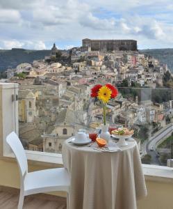 een tafel met een vaas met een bloem erop bij Iblachiara in Ragusa