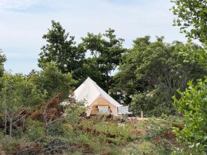 ein weißes Zelt auf einem Feld mit Bäumen in der Unterkunft Seglinge Glamping in Norrön