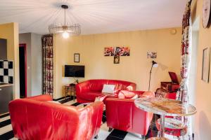a living room with red leather chairs and a table at Guest house Western-city in Chaudfontaine