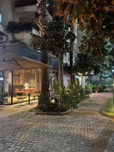 a building with a tree in the middle of a sidewalk at HOTEL Apartments ARDO in Golem