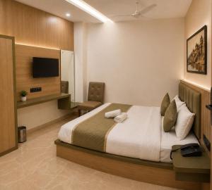 a hotel room with a bed and a tv at New Skyrooms in Varanasi +9 photos