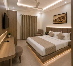 a bedroom with a bed and a desk and a chair at New Skyrooms in Varanasi
