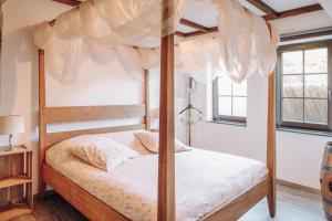 a bedroom with a canopy bed with white sheets at Guest house Western-city in Chaudfontaine