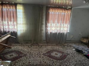 a room with curtains and a floor with two rugs at Jumgal Nomad House in Kyzart