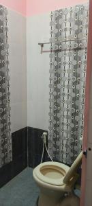 a bathroom with a toilet and a shower curtain at Thendral Falls View Homestay in Kuttālam +12 photos
