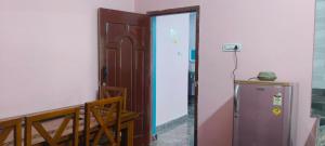 an open door to a room with a refrigerator at Thendral Falls View Homestay in Kuttālam
