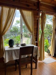 a table in a room with a large window at Nhà Để Chill Homestay in Da Lat