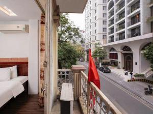 a balcony with a bed and a flag on a street at Van Hoa Boutique Hotel in Hanoi