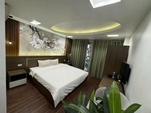 a bedroom with a bed and a painting on the wall at Van Hoa Boutique Hotel in Hanoi +44 photos