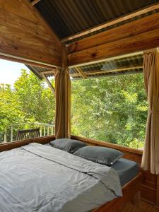 a bed in a room with a large window at Nhà Để Chill Homestay in Da Lat