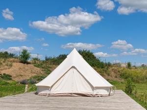 a white tent sitting on a wooden boardwalk at ILLU Glamping in Trebujeni