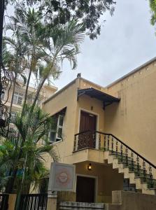 a building with a balcony and palm trees at Pravaha Hostel in Bangalore
