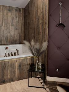 a bathroom with a tub and a table with a vase at Zámoček Mraznica in Prievidza