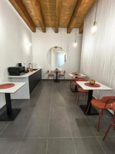 a room with tables and chairs and a kitchen at B&B Piazza d'Armi Lamezia Terme - 3 sorrisi in Lamezia Terme +48 photos