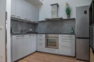 a kitchen with white cabinets and a sink at Ferienwohnung Döller in Gmünd