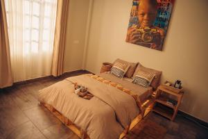 a bedroom with a bed with a stuffed animal on it at Lights & Kulture Homes in Arusha