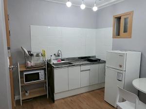 a small kitchen with a sink and a refrigerator at 속초푸른바다펜션 in Puwŏl-li +4 photos