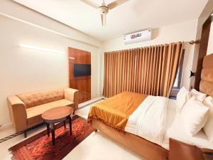 a hotel room with a bed and a bench in it at Comfort Lodge Executive in Islamabad