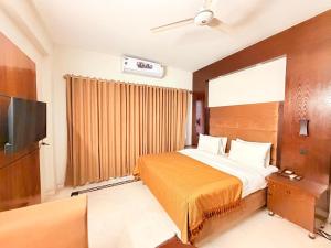a bedroom with a bed and a flat screen tv at Comfort Lodge Executive in Islamabad +12 photos