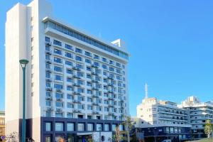 a tall white building with a lot of windows at Ooedo Onsen Monogatari Beppu Seifu in Beppu