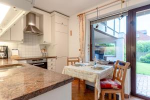 a kitchen with a table and chairs and a window at Romantica EG in Sankt Peter-Ording