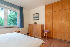 a bedroom with a bed and a dresser and a window at Romantica EG in Sankt Peter-Ording