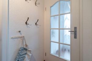 a door with two pairs of glasses hanging on a wall at Romantica EG in Sankt Peter-Ording +11 photos