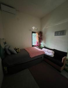 a small bedroom with a bed and a window at Gs Homestay in Banyuwangi
