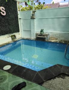 a swimming pool with blue water in a backyard at Gs Homestay in Banyuwangi