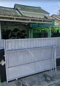 a white fence in front of a house at Gs Homestay in Banyuwangi