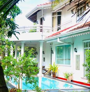 a house with a swimming pool in front of it at The Negombo Manor Villa in Negombo