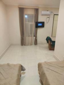 a living room with a television and a tiled floor at Hotel RELAX TIME in Lanch'khut'i +1 photo