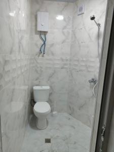 a white bathroom with a toilet and a shower at Hotel RELAX TIME in Lanch'khut'i