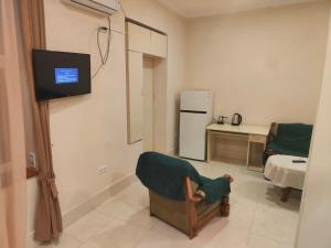 a living room with a chair and a tv in it at Hotel RELAX TIME in Lanch'khut'i
