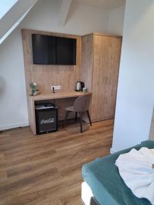 a bedroom with a desk with a television on a wall at VillaWie in Rheda-Wiedenbrück