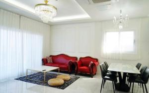 a living room with a red couch and a table at 판포홈치풀빌라 in Wŏllyŏng +25 photos