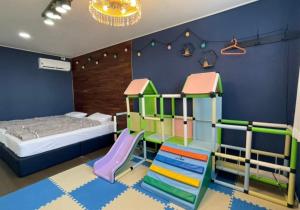 a childs bedroom with a slide and a bunk bed at 판포홈치풀빌라 in Wŏllyŏng