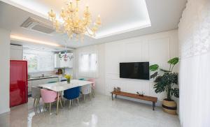 a kitchen with a table and chairs and a chandelier at 판포홈치풀빌라 in Wŏllyŏng