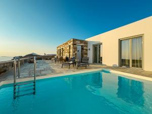 a swimming pool in front of a house at Villa Plora, by Estia in Áno Meriá +32 photos