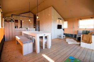 a large room with a table and a kitchen at Glamping de Bosweide in Alphen