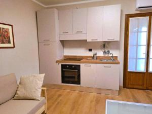 a kitchen with white cabinets and a couch in a room at La Giara in Spoleto